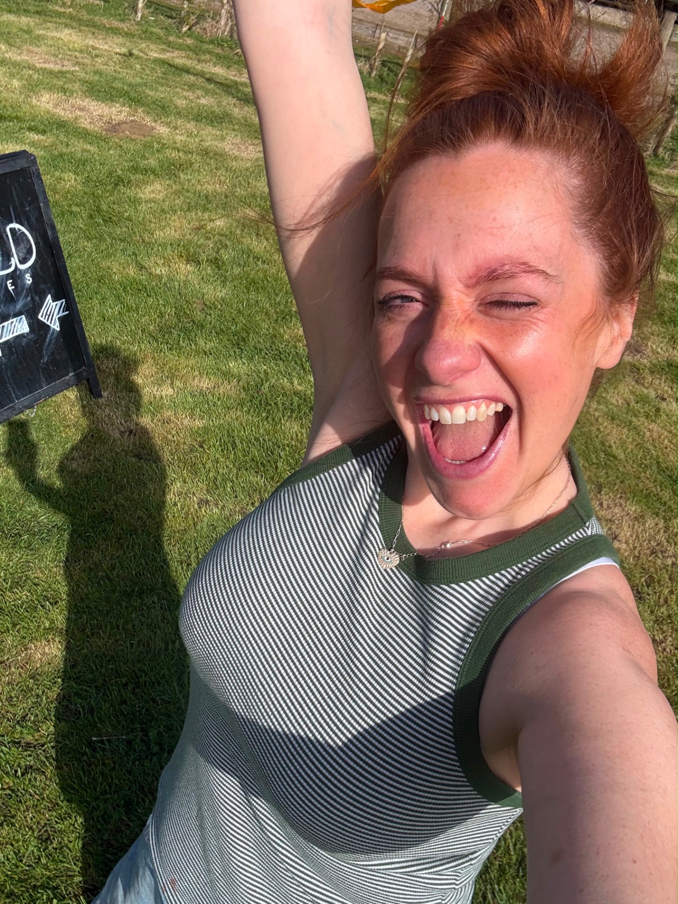 The founder of WildOnes cheering beside the WildOnes sign