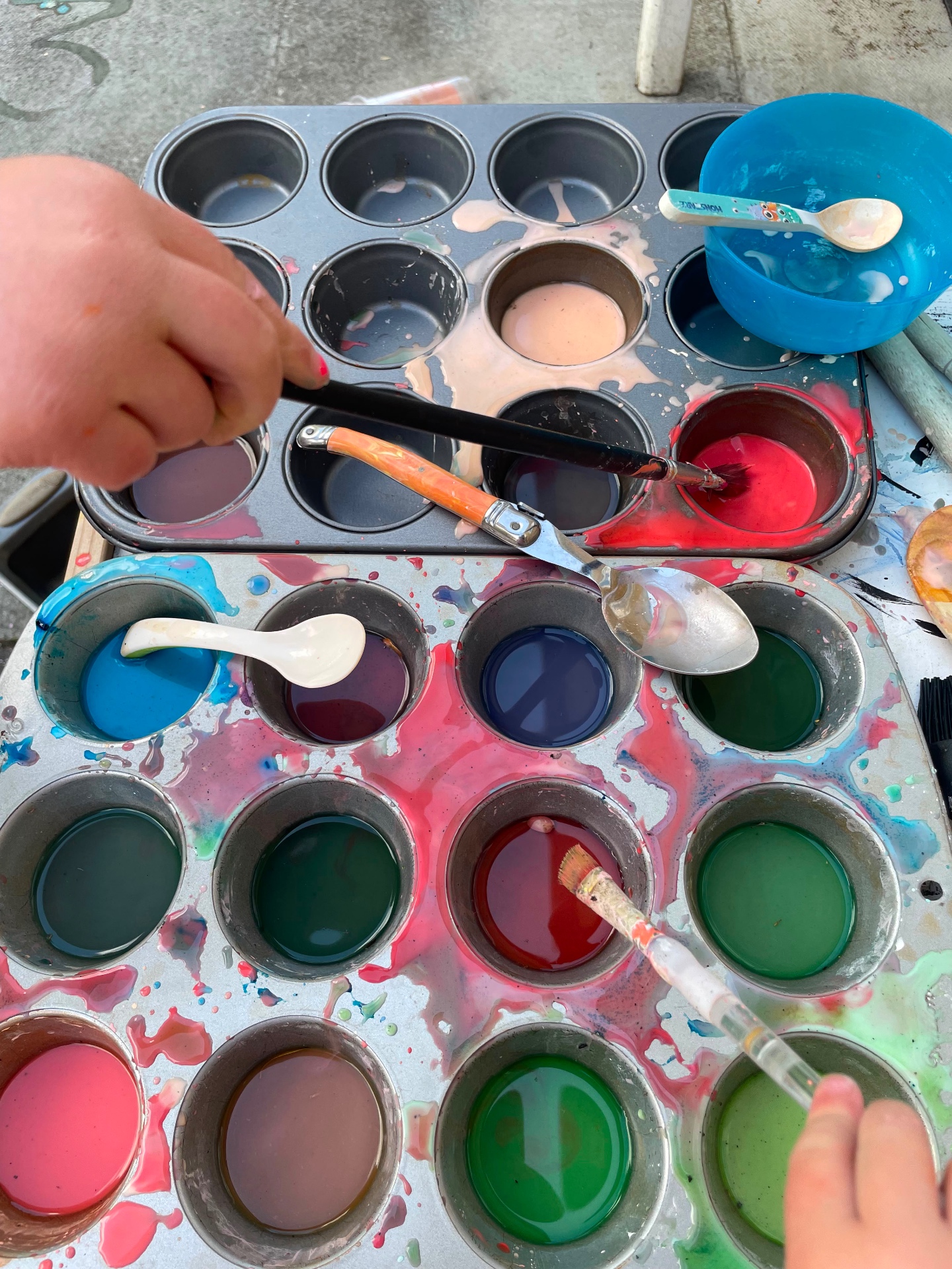 Muffin trays full of bright mixed paints